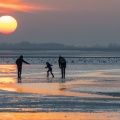 Promeneurs au soleil couchant sur la plage du Crotoy