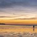 Un pêcheur de vers de vase sur la plage de Ault au pied des falaises