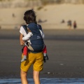 Jeune maman et son enfant en sac dorsal sur la plage