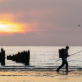 Pêcheur à la ligne sur la plage entre les bouchots