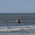 Pêcheur à la ligne sur la plage 