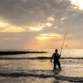 Pêcheur à la ligne sur la plage 