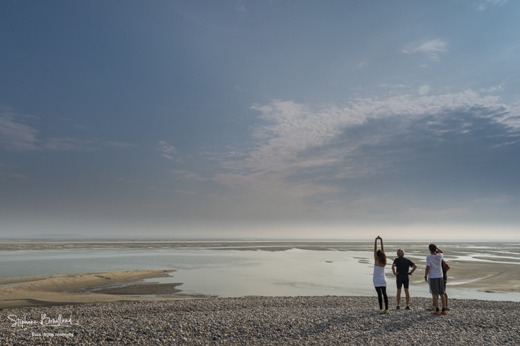 Un groupe de courreurs s'arrête pour admirer la baie à marée basse.