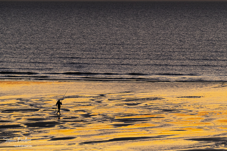 Pêcheurs à la ligne sur la plage à Ault au crépuscule